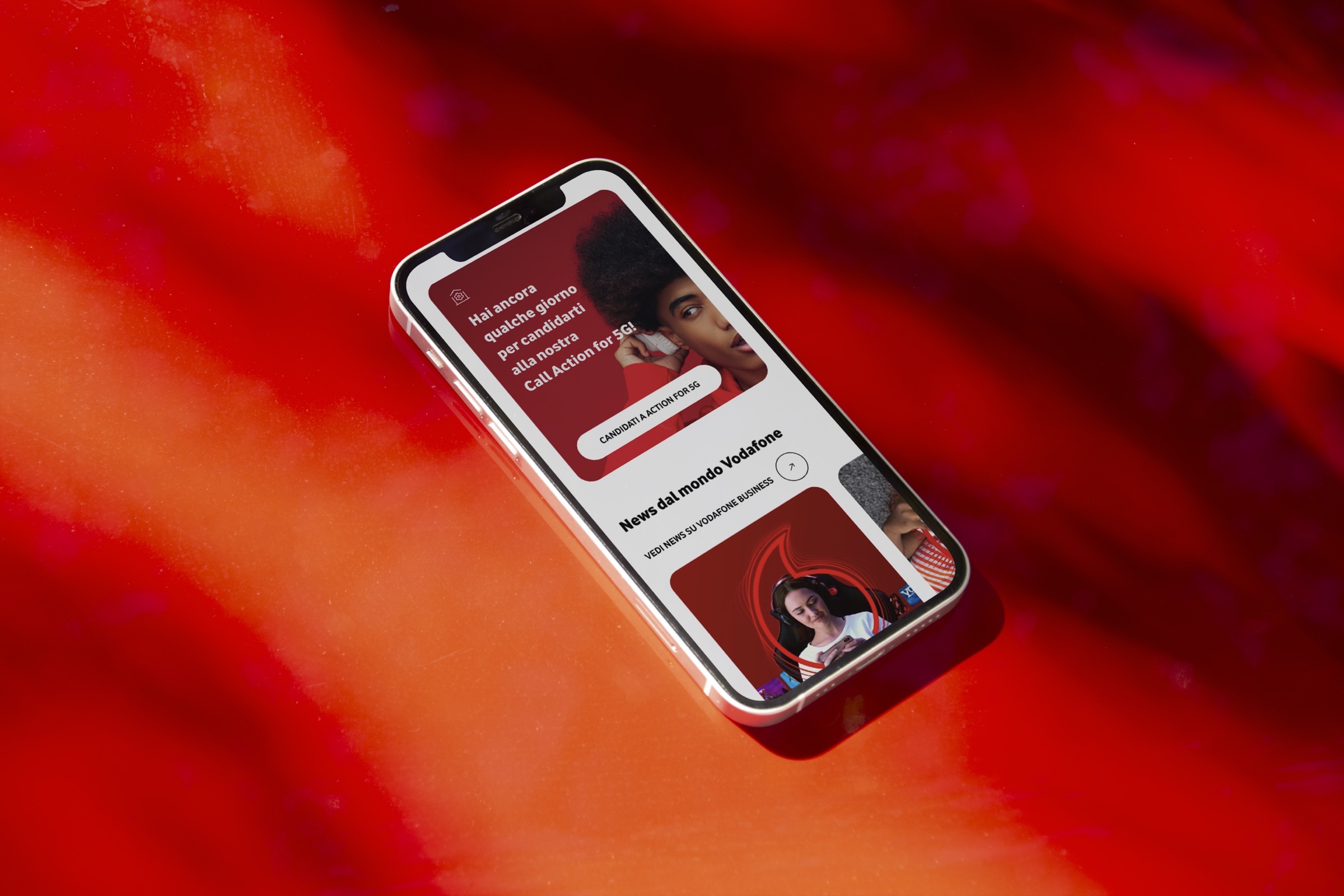 Il sito Open Innovation su smartphone, appoggiato su un fondo rosso Vodafone